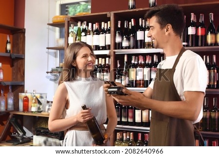 Woman paying for wine in store