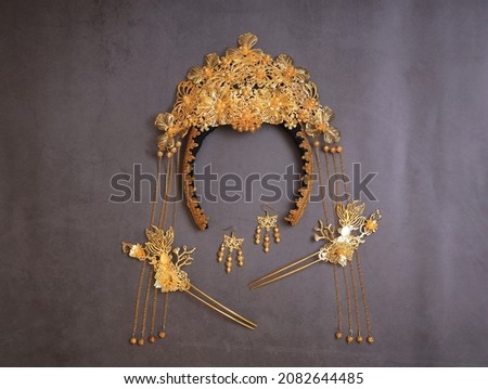 Chinese traditional hairpins hair clips on a grey concrete background. Traditional Chinese women's jewelry, gold hairpins with red gems. Royalty-Free Stock Photo #2082644485