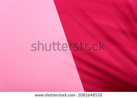Deep red and pink color background with tropical palm shadow. Two trend pastel paper and exotic plant shade layout. Minimal flat lay with leaf silhouette overlay. Royalty-Free Stock Photo #2082648550