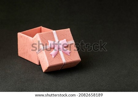 pink gift box with an open lid on a black background with copyspace. High quality photo