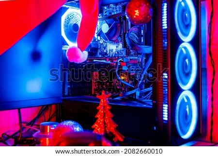Desktop pc with RGB lights by a small Christmas tree and Santa Claus hat 