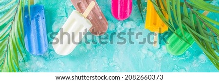 Selection of bright multicolored ice cream popsicle. Various gelato, frozen lollypops - chocolate vanilla blueberry strawberry pistachio orange, with crushed ice on light blue sunny background Royalty-Free Stock Photo #2082660373
