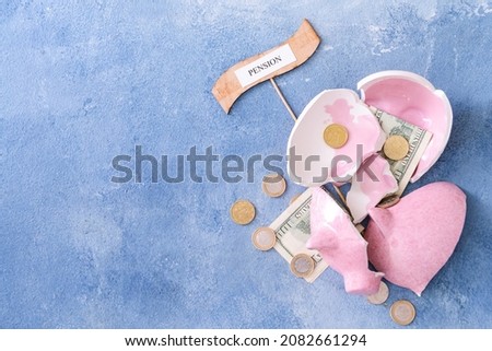 Broken piggy bank with coins and word PENSION on color background Royalty-Free Stock Photo #2082661294