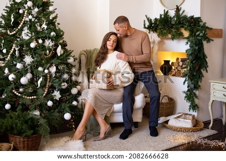 couple at home at Christmas time near beautifully decorated christmas tree
