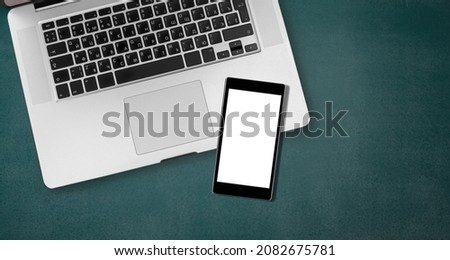 Modern smartphone with a blank screen and laptop