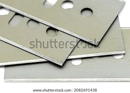 A background made from a macro photo of a pile of razor blades, isolated on a white background. Royalty-Free Stock Photo #2082691438