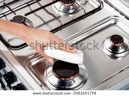 hand of woman cleaning a kitchen with a white scourer Royalty-Free Stock Photo #2082691798