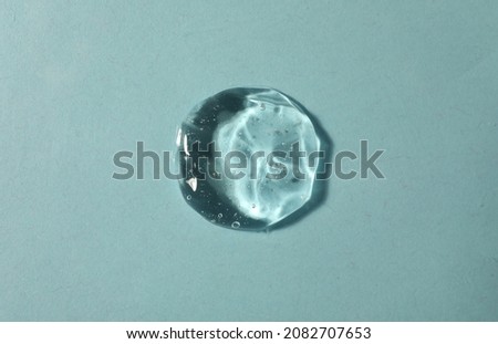 Sample of transparent cosmetic gel on light blue background, top view