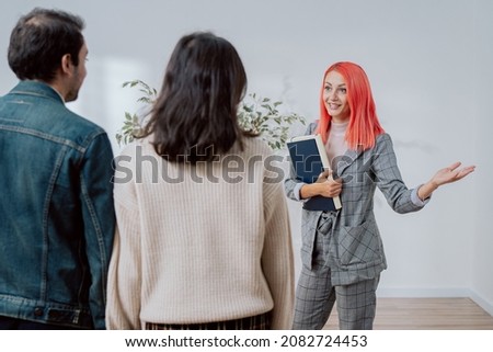 Couple make appointment to see real estate agent pink-haired elegantly dressed owner invites them to look at newly renovated apartment in city center young people think about renting buying first flat