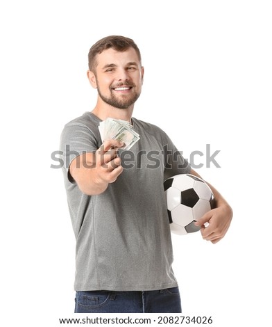 Young man with soccer ball and money on white background. Concept of sports bet Royalty-Free Stock Photo #2082734026