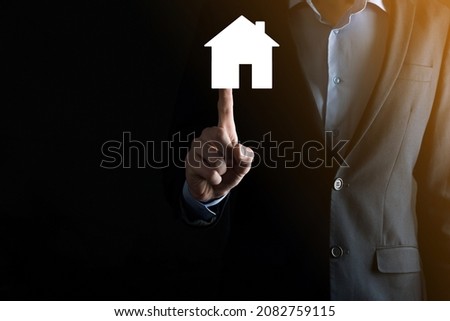 Businessman male hand holding house icon on blue background. Property insurance and security concept.Real estate concept.Banner with copy space