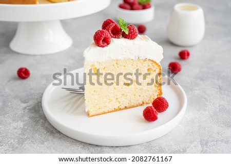 Tres leches cake with whipped cream and fresh raspberries on top of a gray concrete background. Traditional cake from Latin America. Copy space Royalty-Free Stock Photo #2082761167