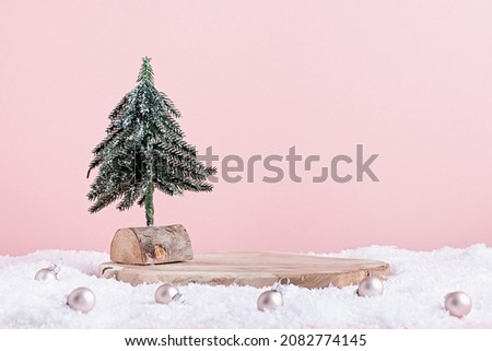 Christmas holiday wooden podium or stand in snow with mini Christmas tree