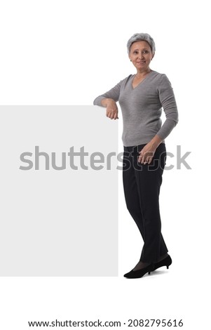 Mature asian business woman is holding empty text sign over white background