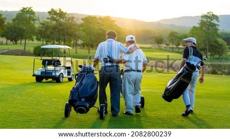 Group of Asian people businessman and senior CEO enjoy outdoor sport  golfing together at country club. Healthy men golfer holding golf bag walking on fairway with talking together at summer sunset Royalty-Free Stock Photo #2082800239