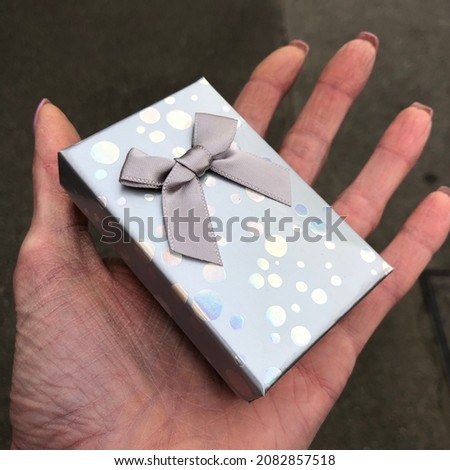 Macro photo gift box with ribbon. Stock photo gift in hand