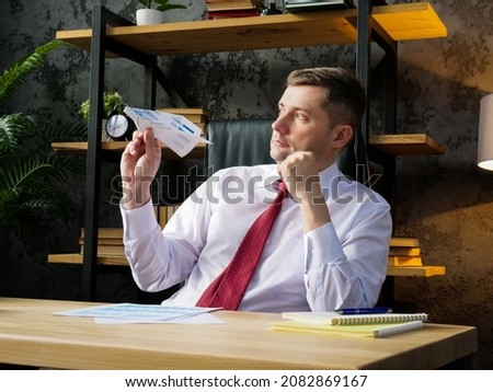 Procrastination and workplace boredom. An employee launches a paper airplane. Royalty-Free Stock Photo #2082869167