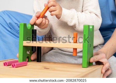 Close up view of a Therapist doing development activities with a little boy. Boy with cerebral palsy having rehabilitation, learning. Training in medical care center. High quality photo.