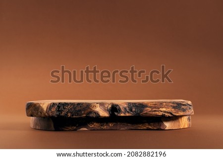 Rustic wood podium display for food, perfume, jewellery and cosmetic products on dark brown background. Front view. Royalty-Free Stock Photo #2082882196