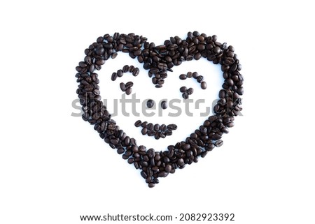 Coffee beans in the shape of isolated on a white background. Smiling Heart made of coffee beans on white background.