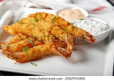 Fried shrimps on sticks in crispy coating with sauce
 Royalty-Free Stock Photo #2082941806