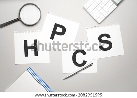 magnifier,calculator, pen and paper sheet with text hpcs