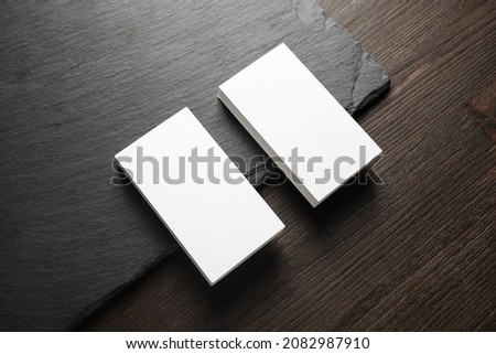 Photo of two stacks of blank business cards on stone board background.