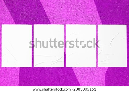 Closeup of geometrical purple and pink painted urban wall texture with four wrinkled glued poster templates. Modern mockup for design presentation. Creative geometric urban city background. 