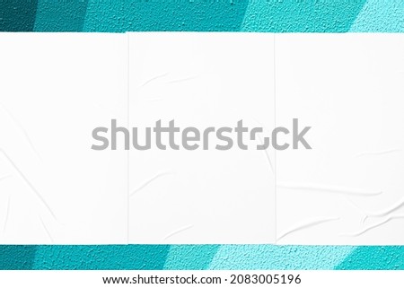 Closeup of geometrical teal mint green painted urban wall texture with three wrinkled glued poster templates. Modern mockup for design presentation. Creative geometric urban city background. 
