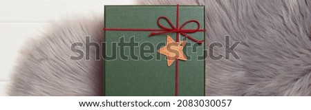 Green gift box on fluffy carpet. Christmas new year shopping sale concept.