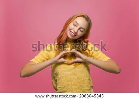 Smiling friendly young girl volunteer make heart gesture, love sign. Charity, donation, concept of good deeds