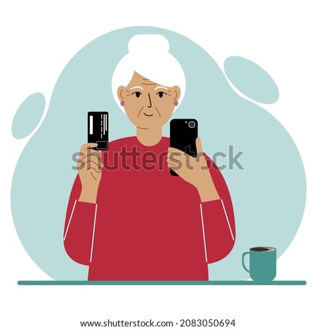 Grandmother holds a mobile phone in one hand and a plastic card in the other. An older woman is learning to pay online.