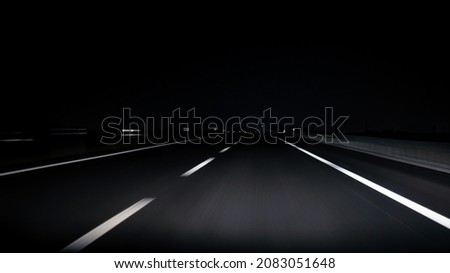 POV view of car driving on road of highway at night in Spain. Drive on an empty road in the dark evening. A car drives on a freeway. Asphalt with white line at new road. Royalty-Free Stock Photo #2083051648