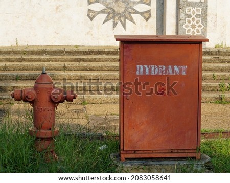 View of hydrant in the grass of park with stairs as background.