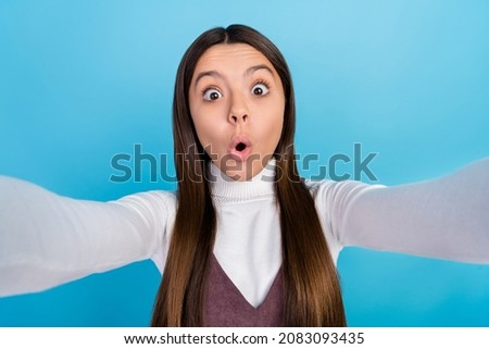 Photo of young astonished girl fake information take selfie vlogging isolated over blue color background