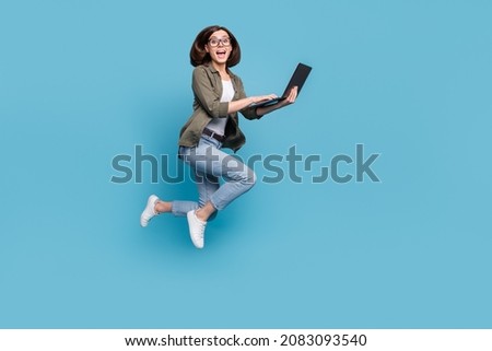Full length photo of lady it developer jump use device online discount wear denim jeans shirt isolated over blue color background
