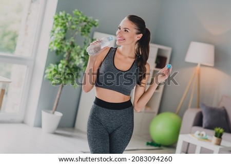 Photo of adorable pretty girl dressed sport suit back chair drinking water after training smiling indoors house home Royalty-Free Stock Photo #2083094260