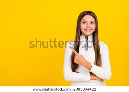 Photo of dreamy shiny student girl wear white zip shirt smiling pointing finger empty space isolated yellow color background