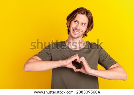 Photo of young cheerful man wondered show fingers heart symbol love romantic isolated over yellow color background
