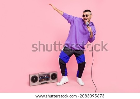 Full body photo of young excited guy street artist sing mic pop music boombox isolated over pink color background