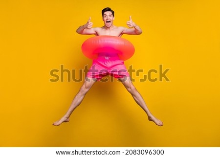 Full body photo of funky millennial guy jump wear buoy pink shorts isolated on yellow background