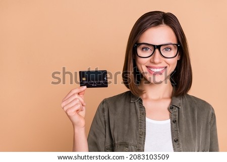 Photo of confident lady demonstrate debit card new bank promo wear specs khaki shirt isolated beige color background