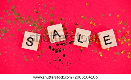 Wooden cubes with the inscription SALE on afastive red background
