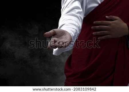 Jesus Christ with open palm giving helping hand with dark background