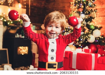 Kids Joy and happiness. Childhood moments. Kid boy santa hold christmas balls.