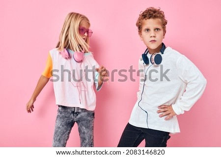 funny little boy and girl wearing headphones posing Listening music