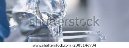 Water is poured from transparent bottle into glass. Drinking regime of the day for health concept Royalty-Free Stock Photo #2083146934