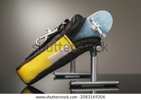 A small fingerboard bag and metal railings on a gradient background