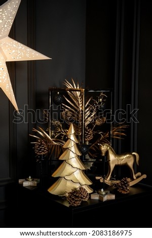 Merry Christmas and Happy Holidays!Beautiful black modern living room decorated for Christmas.Chrystmas Luxury black style living room interior with sofa decorated chic , golden style.Selective focus. Royalty-Free Stock Photo #2083186975