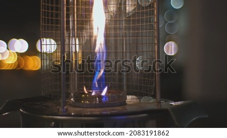 Restaurant Outdoor Patio Garden Gas Heater with Blue and Yellow Flame Burning on Cold Autumn Evening